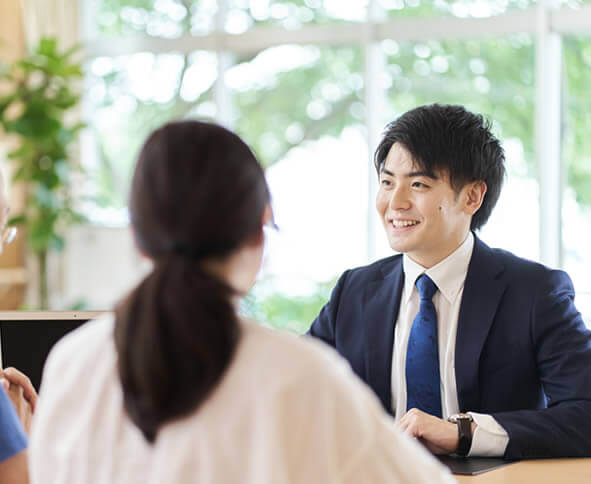 スーツを着た男性とお客様の後ろ姿の写真|北海道札幌の相続不動産買取専門 ご遺族支援 遺品整理 遺言 死後事務委任